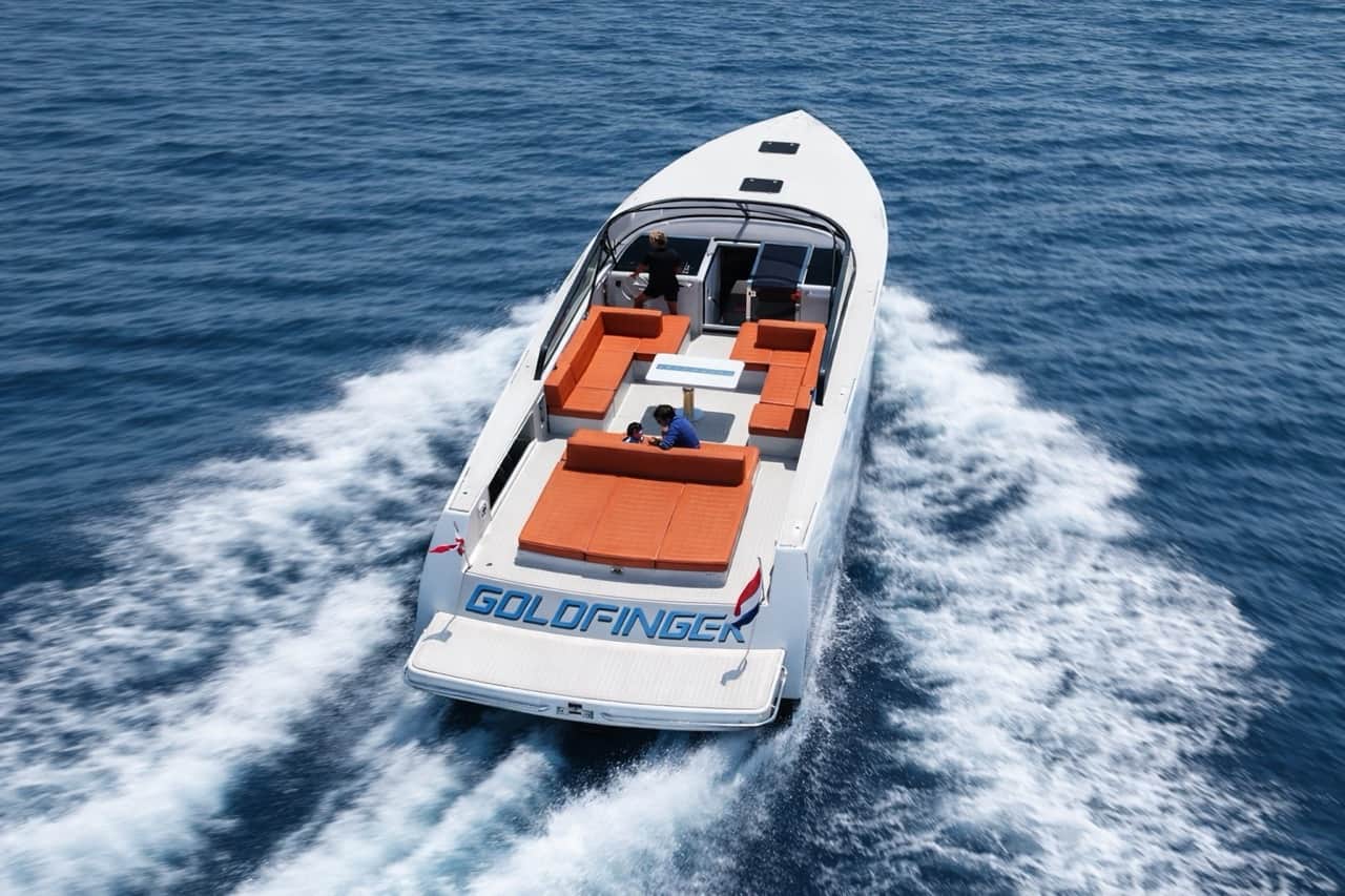 Vanquish VQ45 Goldfinger luxury yacht aerial view — orange deck seating, cruising at speed off the Sardinia coast near Olbia