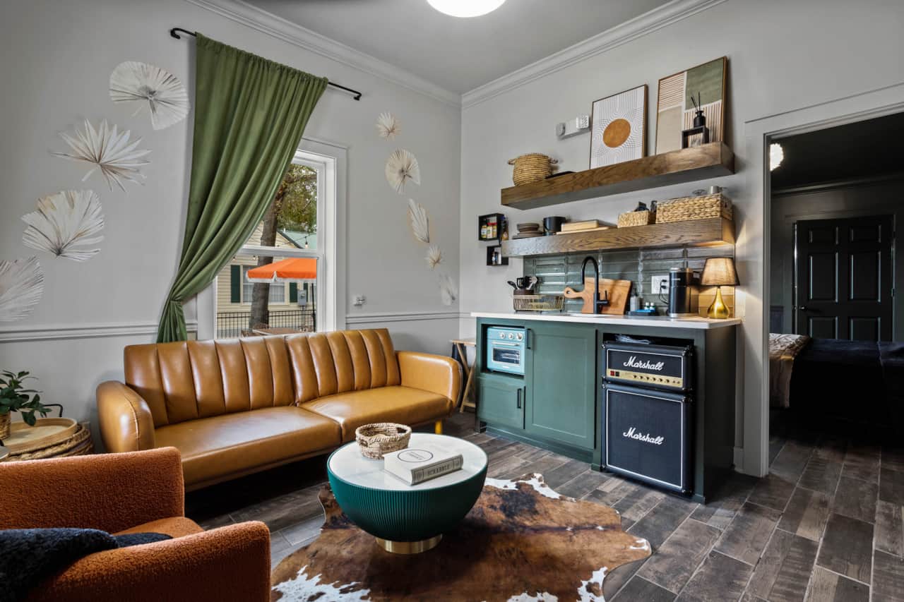 Separate living room with one of two full sofa sleepers and stocked tiny kitchen for light meal prep