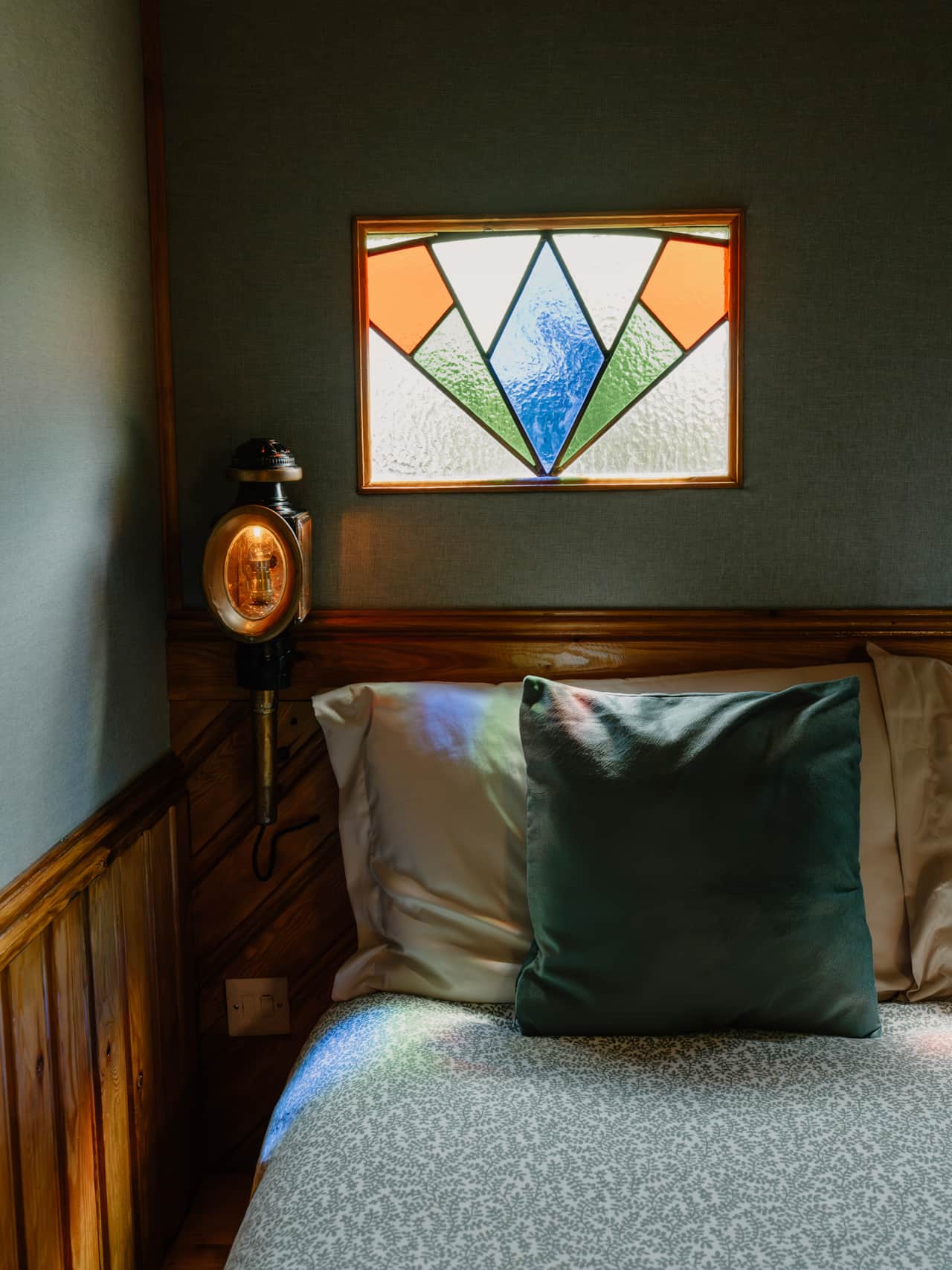 Bedside lights fashioned from old coach lamps.