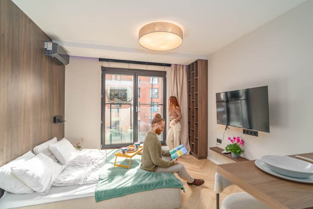 Bright rest area with a large bed and wooden accent wall.
