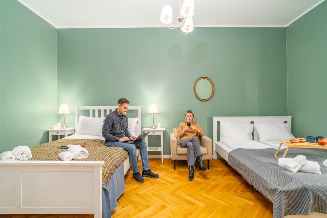 Przestronna, harmonijna sypialnia z dwoma łóżkami i miękkim, nastrojowym oświetleniem.