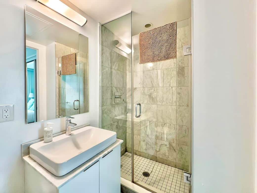 Refresh and unwind in a modern full-size bathroom featuring a sleek shower, clean fixtures, and essential toiletries. Thoughtfully designed for comfort and convenience, it’s the perfect spot to start your day or relax after a long one.