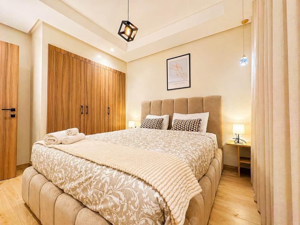 Spacious bedroom featuring a cozy queen bed, elegant décor, and a peaceful ambiance for restful nights.