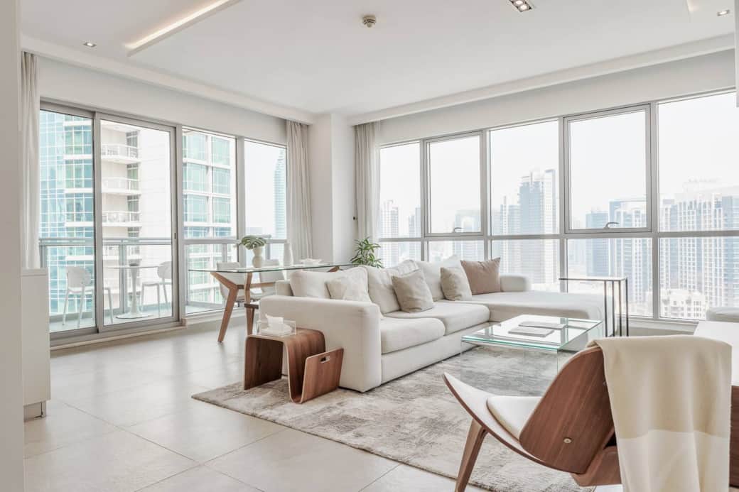 Spacious living room with modern furnishings, smart TV, and floor-to-ceiling windows perfect for relaxing or entertaining with stunning Downtown Dubai views.