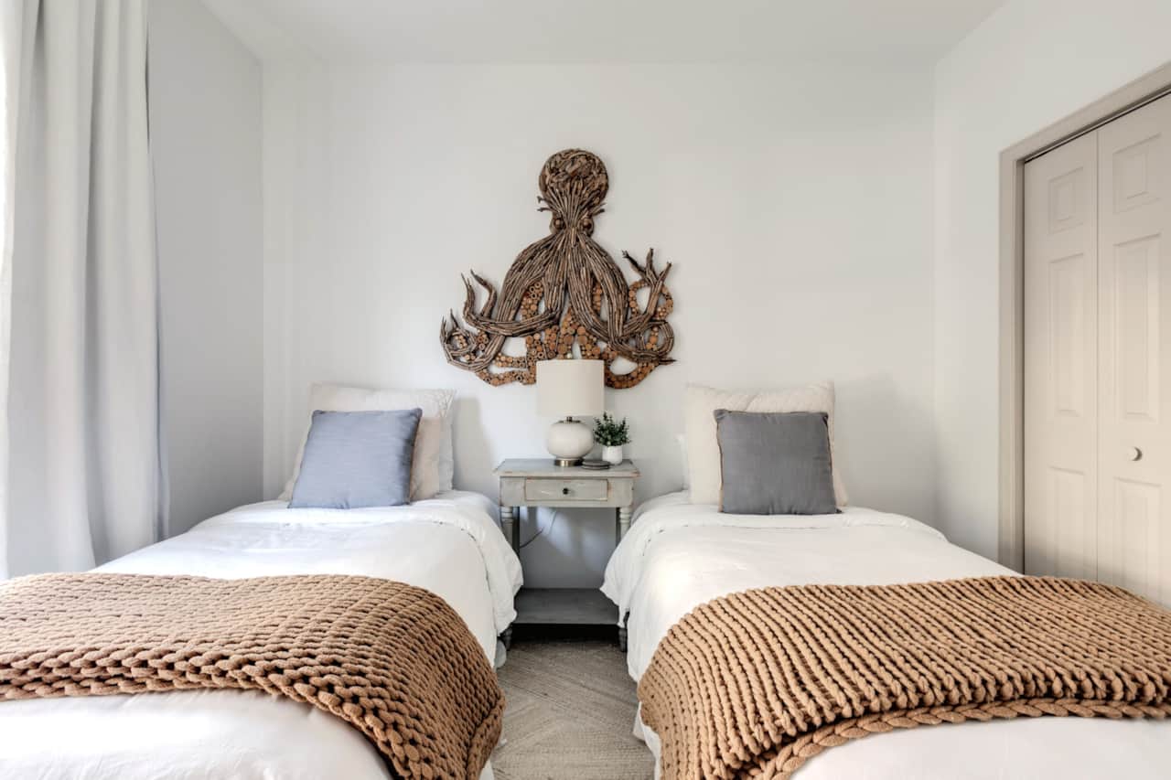 Second floor guest room with two twin beds, tv and private bathroom.