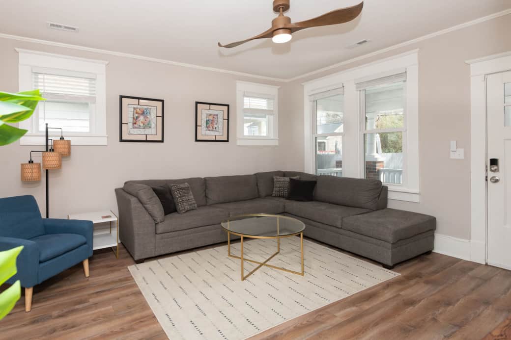 Living room with large couch, ceiling fan, and 55" smart TV. 