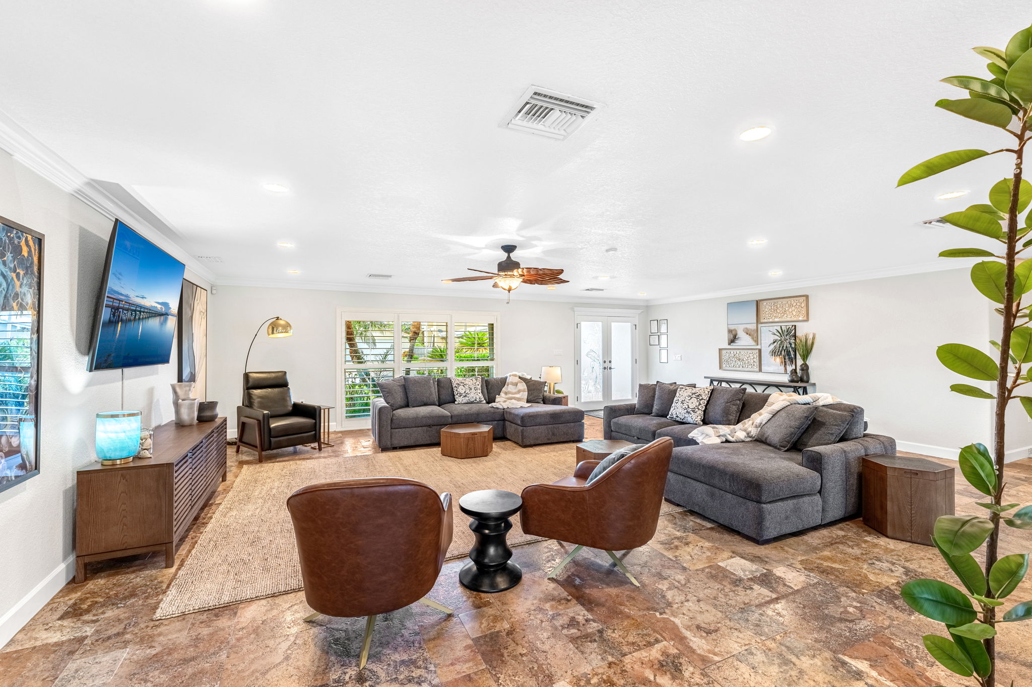 Large windows flood the living room with natural light, offering the perfect space for lounging.