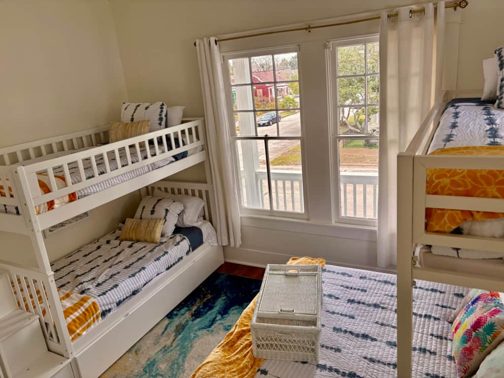 Wide view showing the full sleeping setup with multiple beds in the family room at White Magnolia Galveston