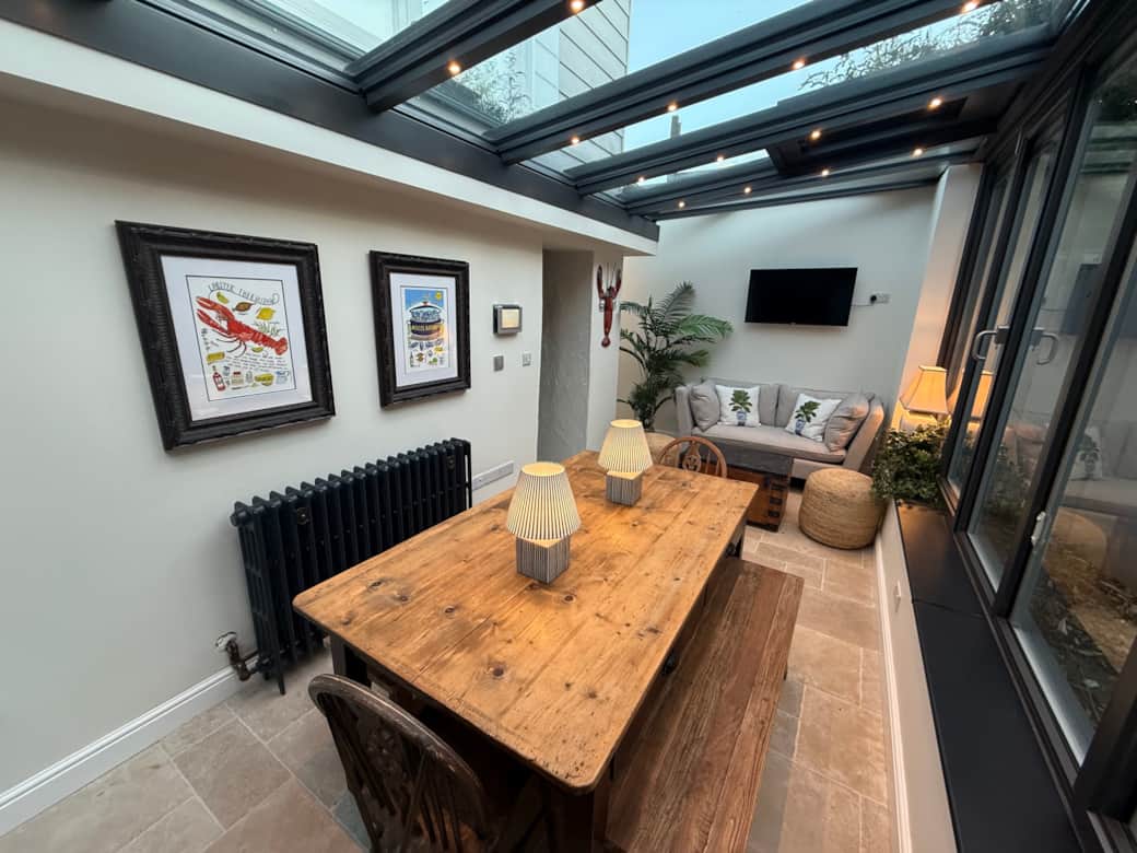 Spacious dining area with large rustic wooden table and vintage bifold doors