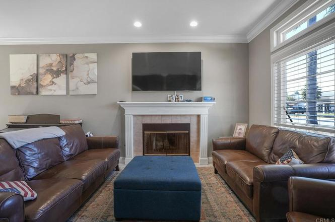 Comfortable living room with leather sofas, a fireplace, and a wall-mounted TV.