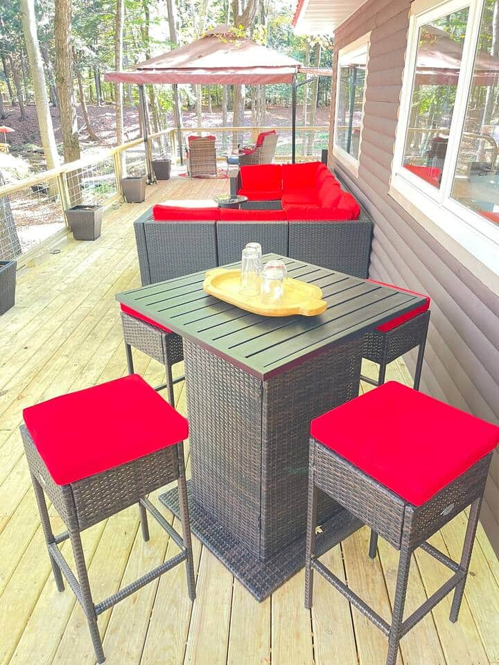The deck includes a high table with four chairs, perfect for enjoying meals or drinks outdoors.