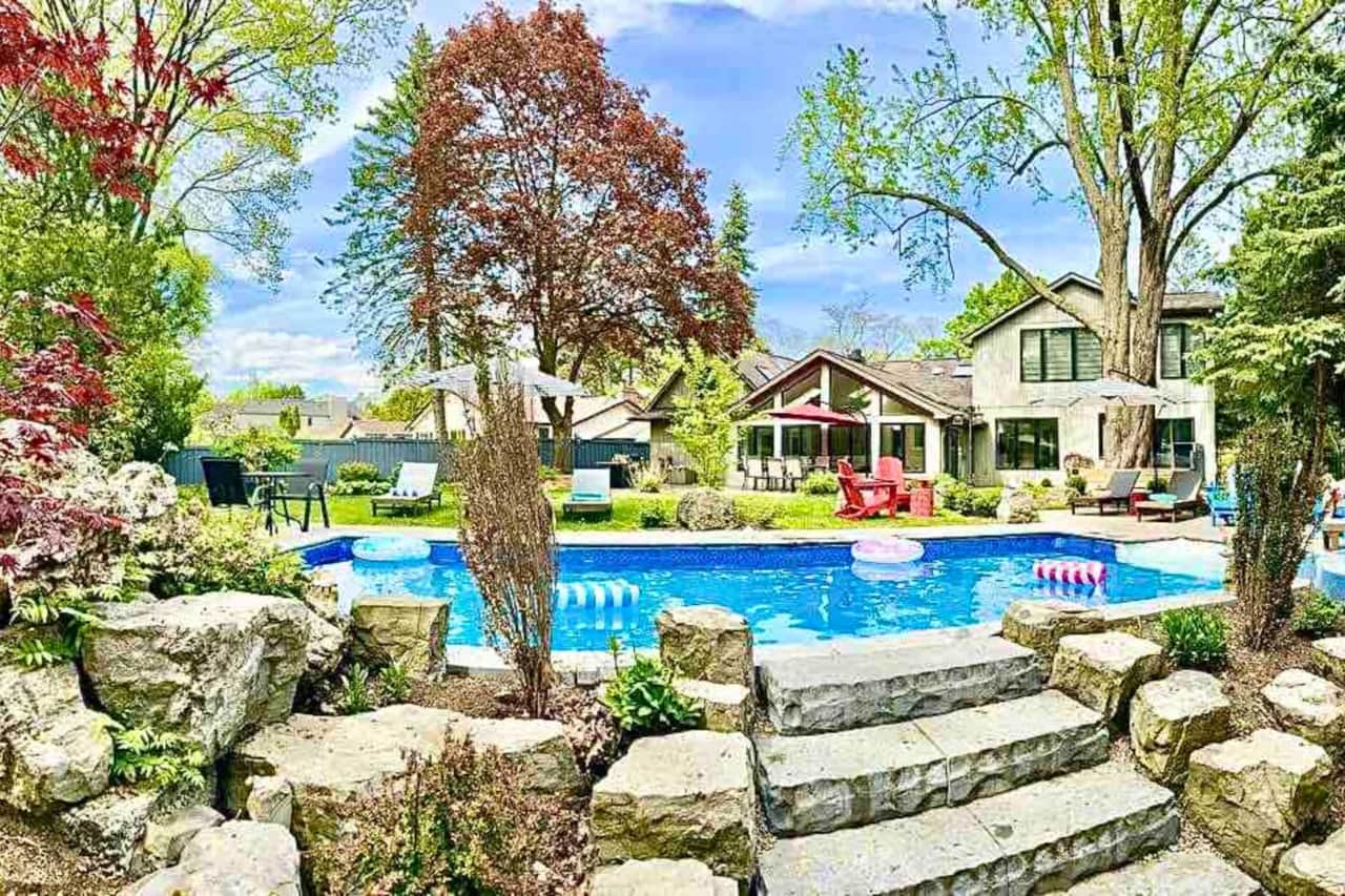 Our backyard offers a true resort like feel with a pool and connected tub, water fall, lounge chairs and a view of the beautiful ravine. 