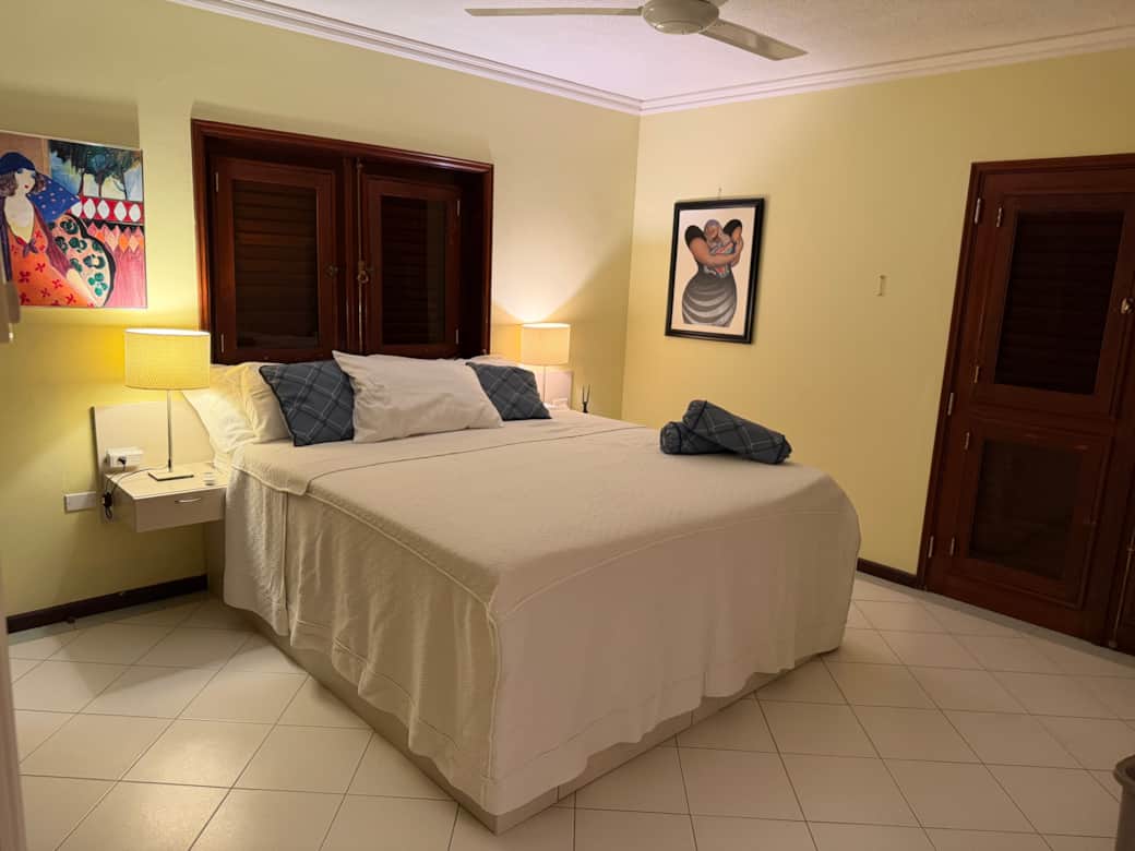 Master bedroom met kingsize bed, eigen badkamer, airco, tv en ruime kledingkasten.