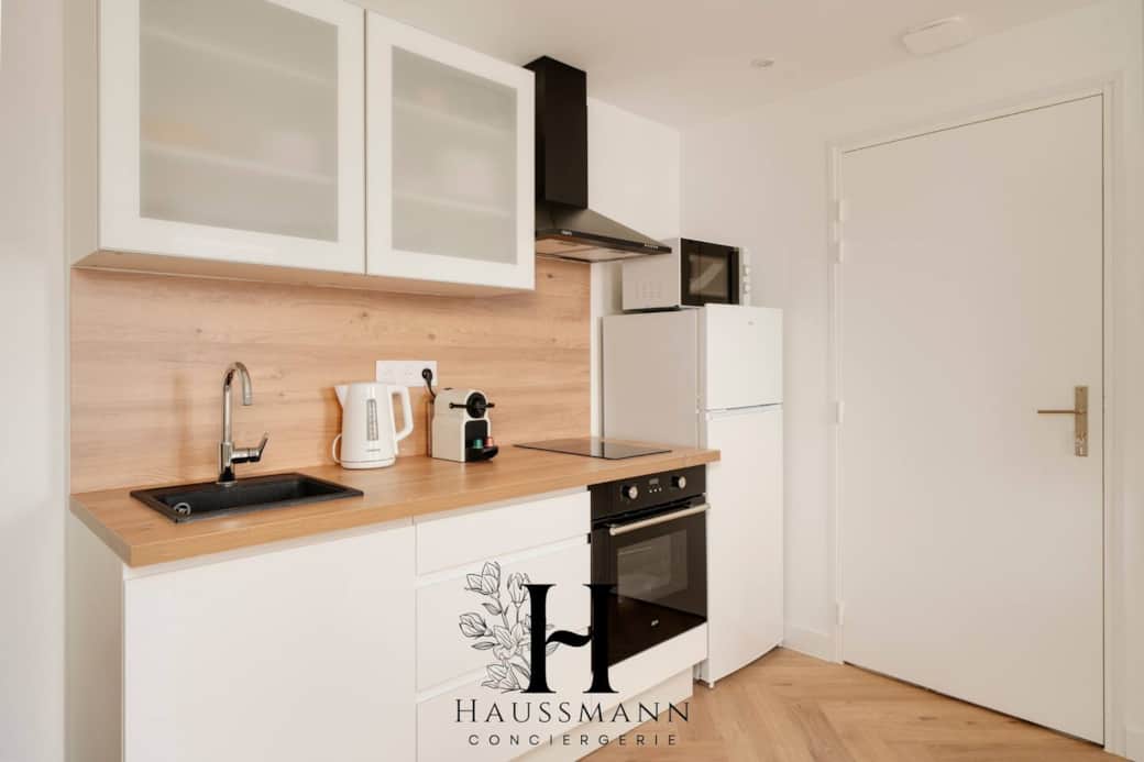 Cuisine moderne entièrement équipée : four, plaques, hotte, micro-ondes, réfrigérateur, bouilloire et vaisselle complète. Tout le nécessaire pour préparer vos repas comme à la maison, dans un espace fonctionnel et élégant.
