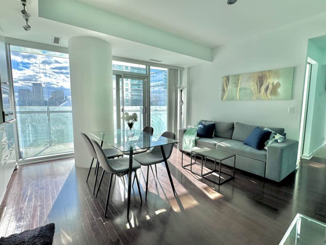 Unwind in a spacious living room with a cozy couch, 42” Smart TV, blazing-fast Wi-Fi, and breathtaking CN Tower views. Perfect for streaming, relaxing, or enjoying the stunning city skyline morning to night in total comfort and style.