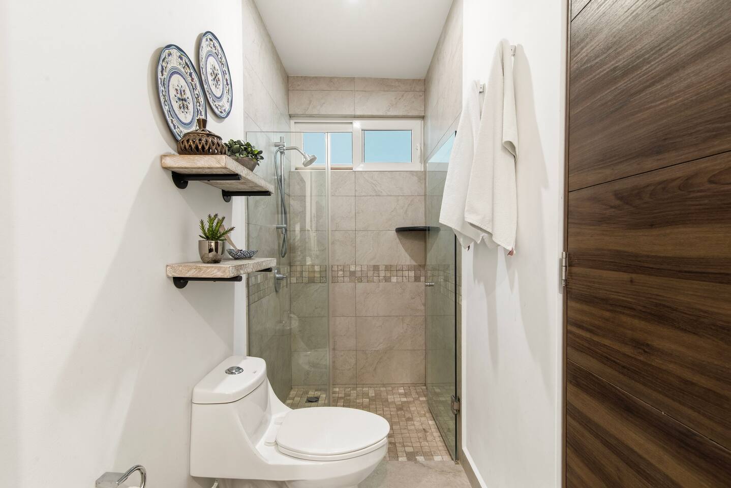 Disfrute de un cómodo baño con ducha a ras de suelo, toallas frescas, champú, acondicionador y jabón, todo lo que necesita para una estancia cómoda y relajante.