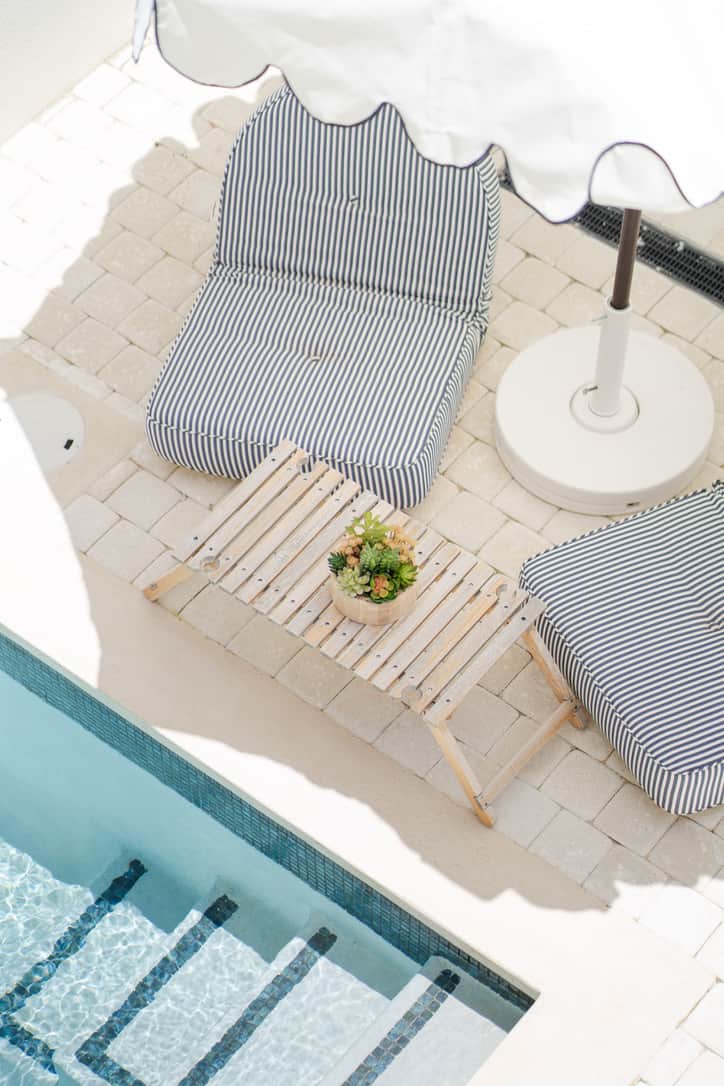 Private plunge pool surrounded by lush greenery and sun loungers.