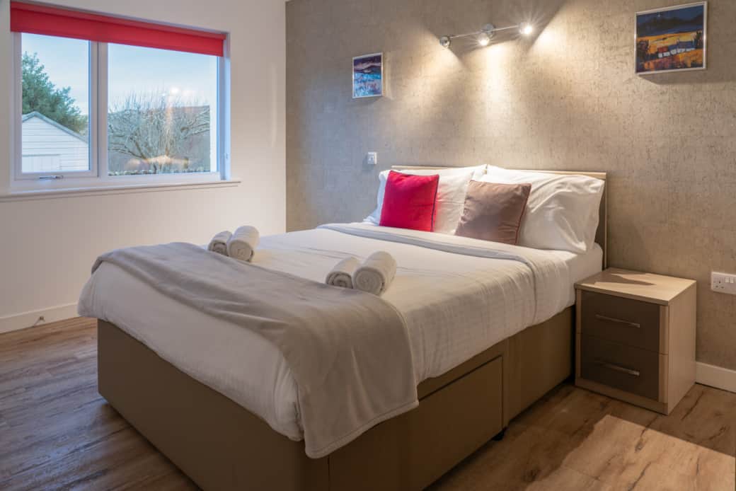 The master bedroom features an en-suite bathroom with a view of the gardens.