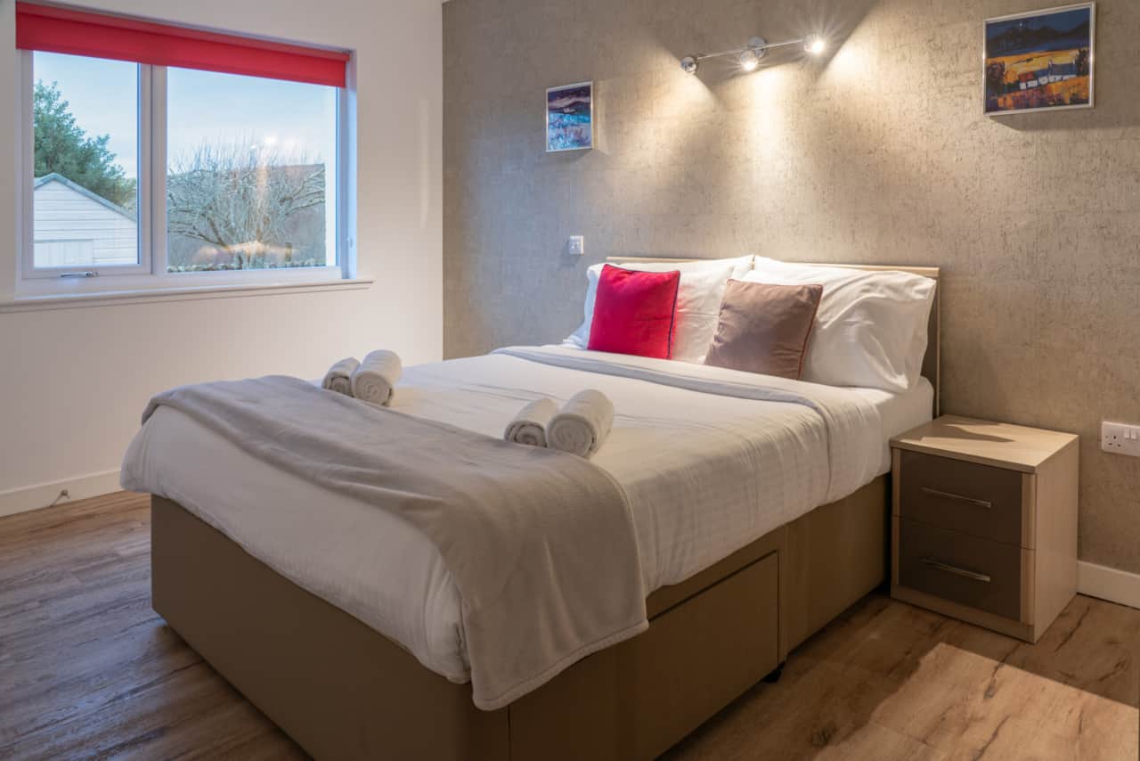 The master bedroom features an en-suite bathroom with a view of the gardens.