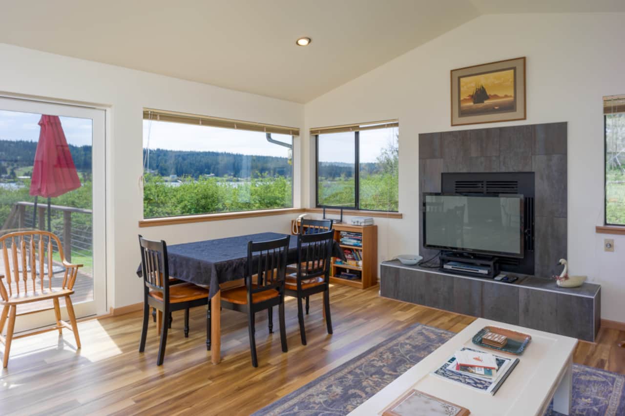 The dining table sits in the windows facing the water.