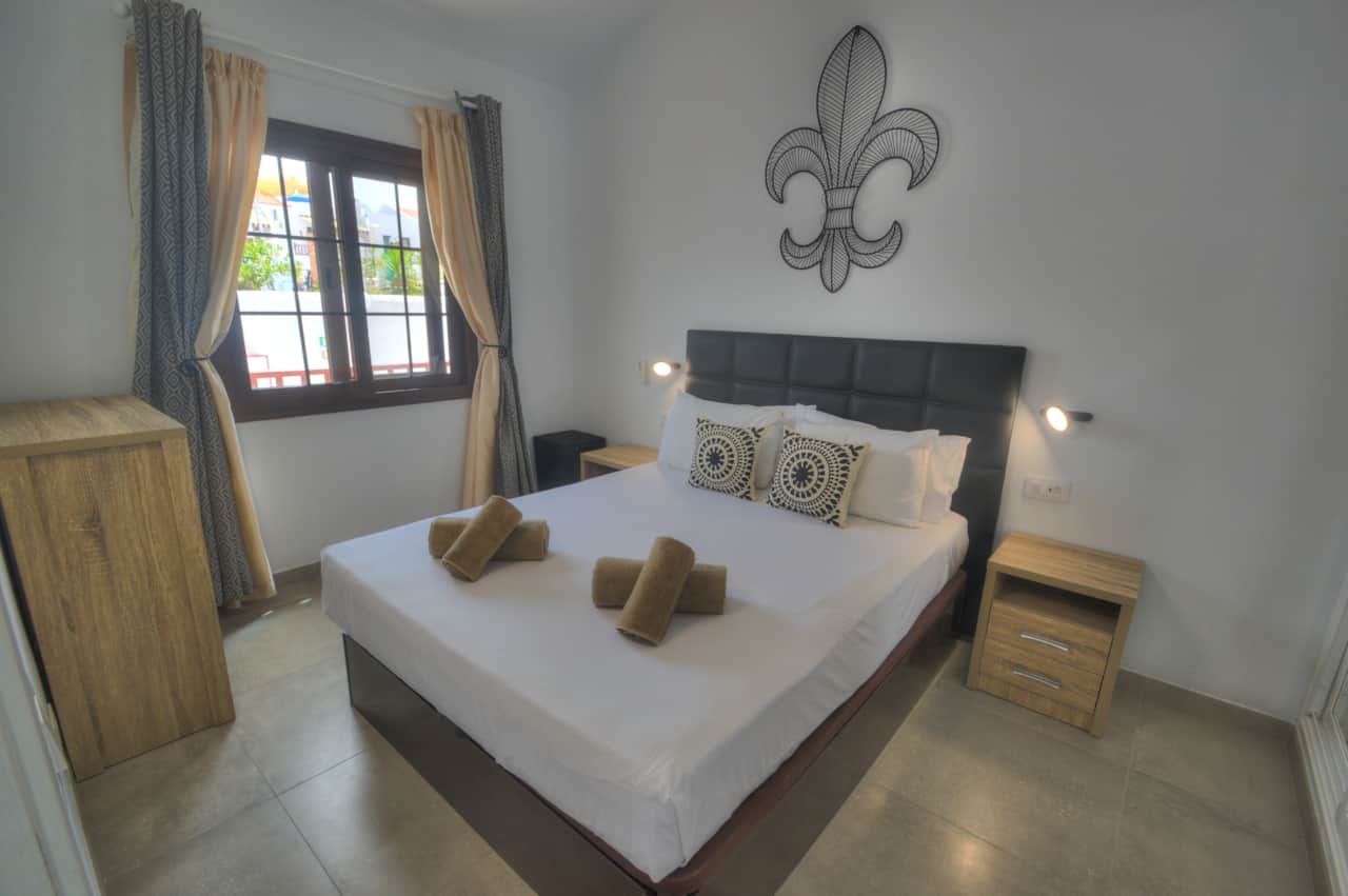Dormitorio con cama de matrimonio y TV.