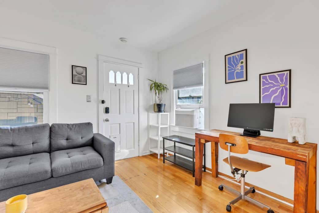 Chic living room with sofa and workspace, ideal for relaxing or getting work done. Chic living room with sofa and workspace, ideal for relaxing or getting work done.