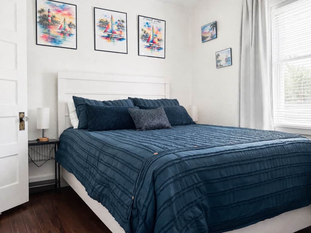 Comfortable, light-filled bedroom with soft linens, bold artwork