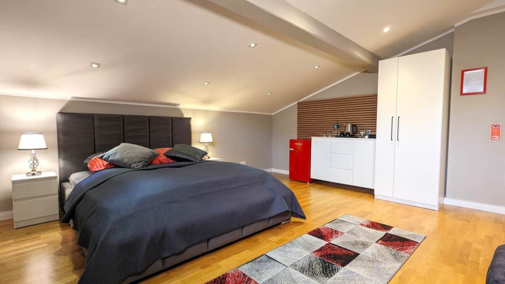 Ruhiges Zimmer mit großzügigem Doppelbett und eleganter Ausstattung für erholsamen Aufenthal