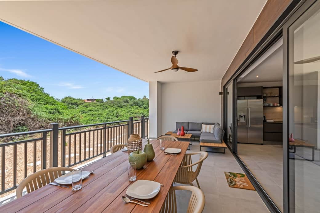 Terrace with large dining table, ceiling fan, comfortable couch and privacy