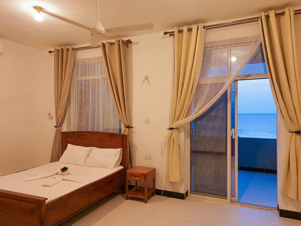 Bright 2BR ensuite room with a comfortable wooden bed, crisp white linens, and soft décor. Includes air-conditioning, large windows, and a private balcony with ocean views. A peaceful, relaxing space filled with natural light and modern comfort. ✨ Bright 2BR ensuite room with a comfortable wooden bed, crisp white linens, and soft décor. Includes air-conditioning, large windows, and a private balcony with ocean views. A peaceful, relaxing space filled with natural light and modern comfort. ✨