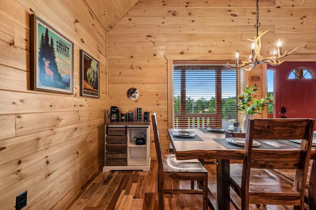 A charming dining nook with rustic wood furnishings, Smoky Mountain artwork, and coffee station