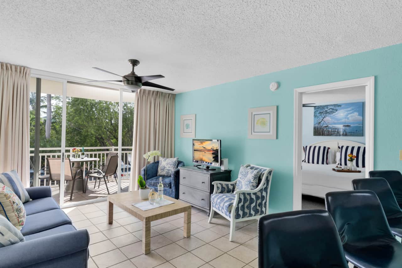 Bright coastal living room with balcony access and tropical-inspired decor throughout.