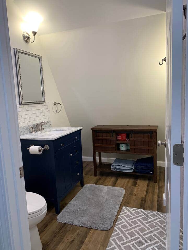 Gorgeous bathroom with marble vanity, towel and linen storage, large shower with handheld