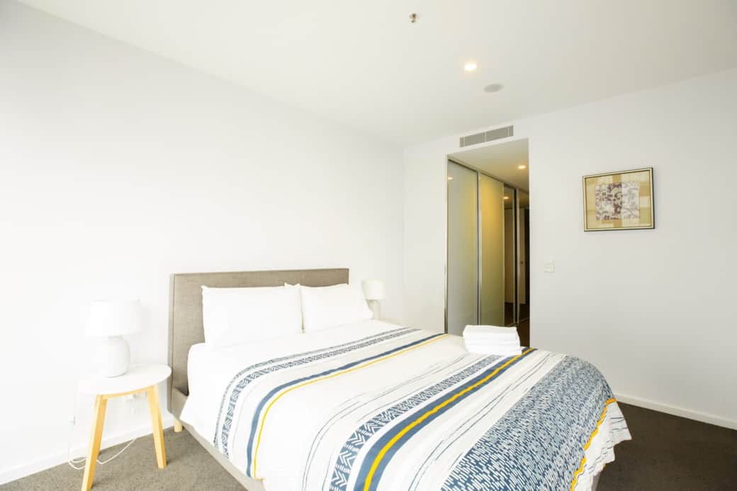 The twin bedroom is designed for comfort and functionality, featuring a queen-size bed. The room is bright and airy, with a large window that lets in plenty of natural light. 