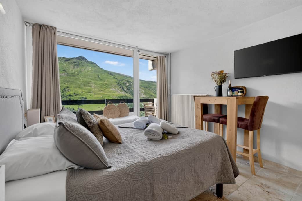 Bright living room and panoramic bay window opening onto the mountains.