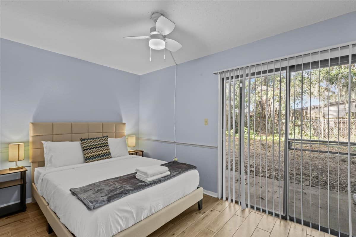 8. First queen bedroom, drawer in front of bed and sliding door exit to patio area