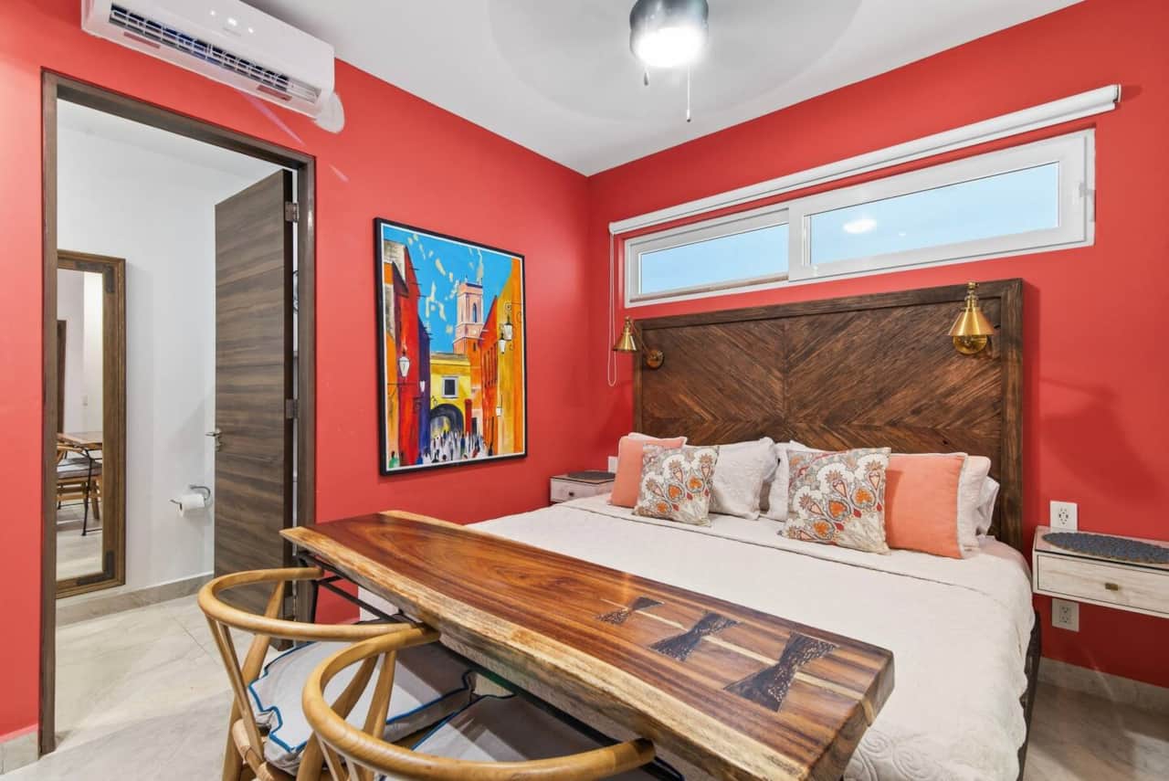 Unwind in this lock-off bedroom with its own entrance, king-size bed, en-suite bathroom, A/C, ceiling fan, and room-darkening shades. Enjoy a wooden table for two for dining or working, plus bedside light switches and outlets for charging devices.