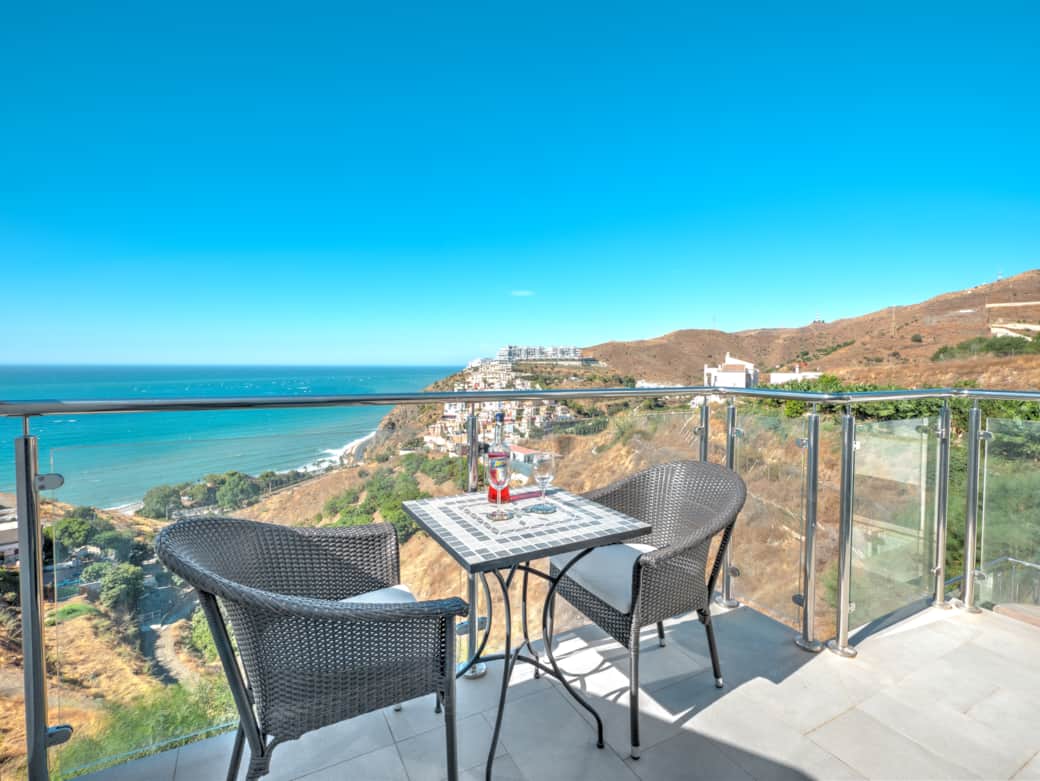 Seating area by the glass railing, perfect for watching the sea. Seating area by the glass railing, perfect for watching the sea.