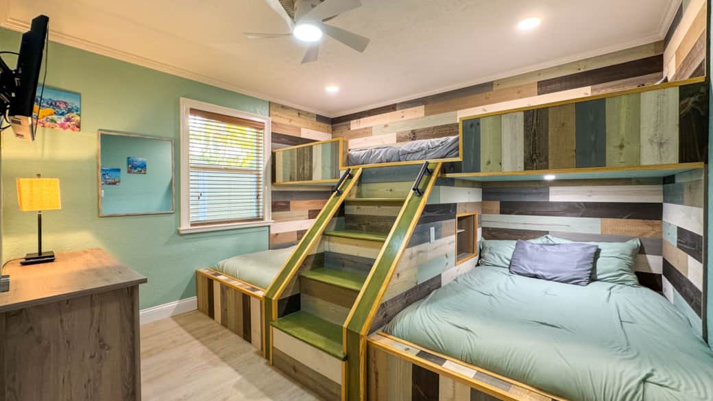 Bedroom 1 with two double beds below and a twin bunk above