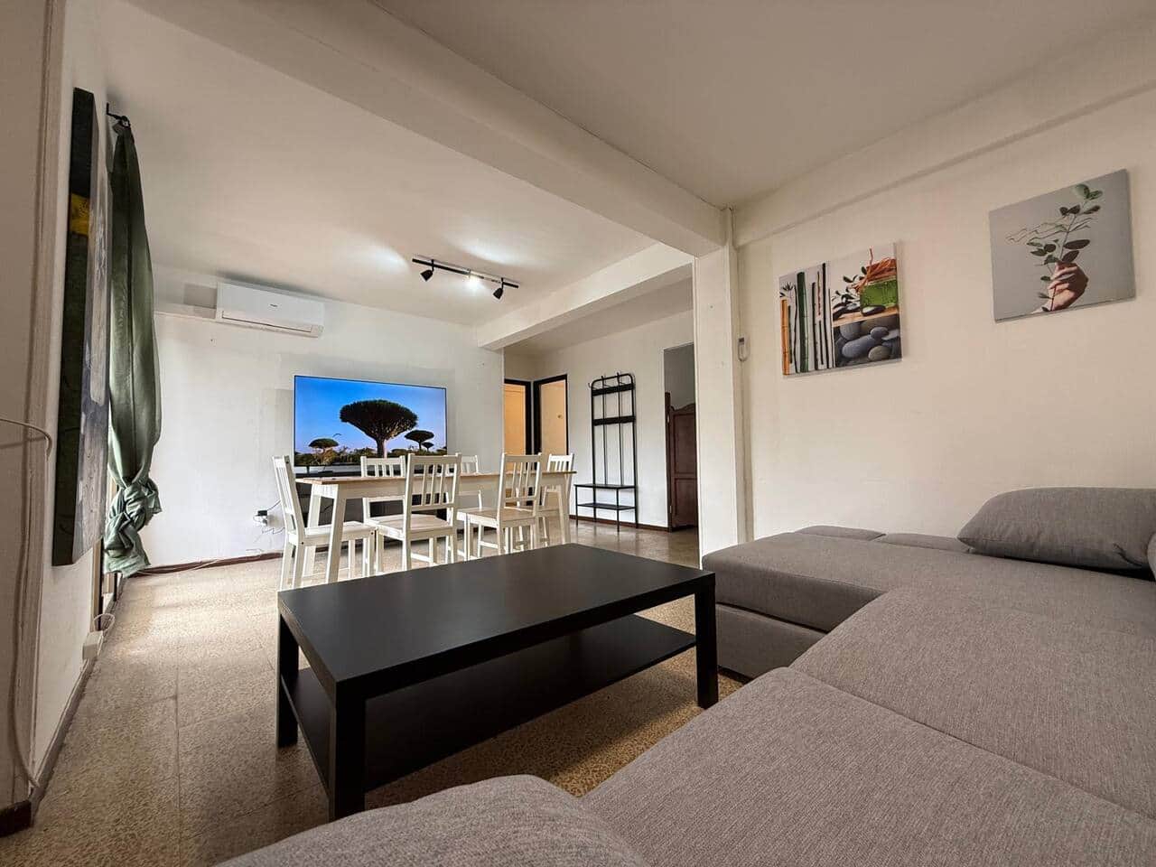 Salón comedor con sofá cama, TV y aire acondicionado