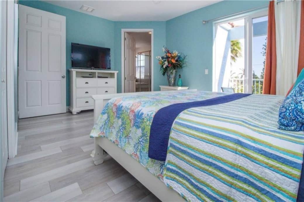 The tranquil master bedroom with a private balcony with peaks of the bay.