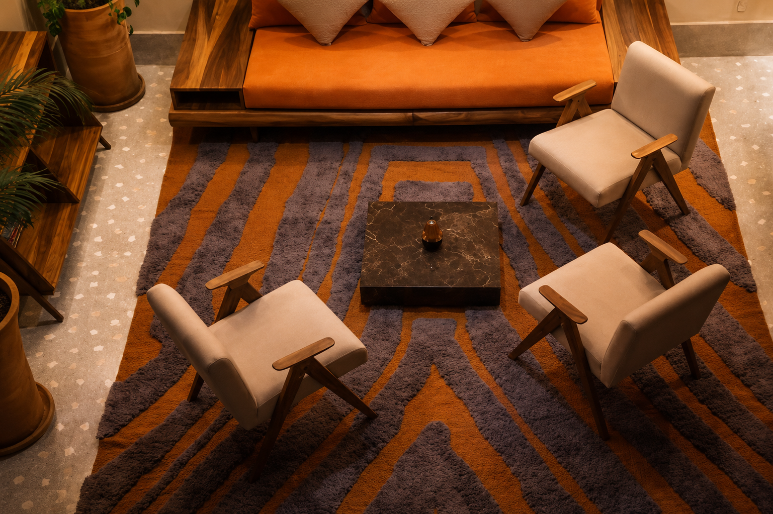 Banquette en teck, fauteuils dans la lignée de Pierre Jeanneret, table basse en marbre noir. Le tapis reprend l'orange brûlé qui traverse la maison. Télévision avec Netflix.