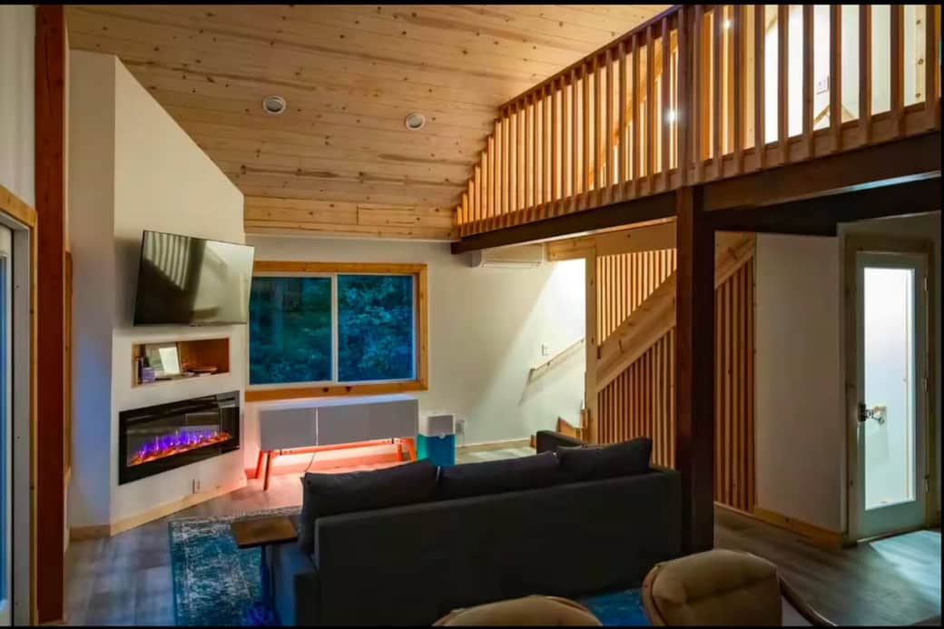 Cozy living room with warm lighting, smart TV, and fireplace—perfect for relaxing nights in.