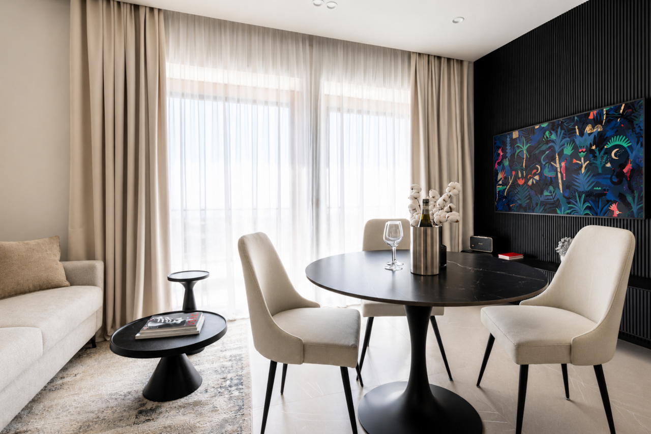 AZULIS DelleTerme Suites Living and dining area with smart TV and round dining table by RENTAL12