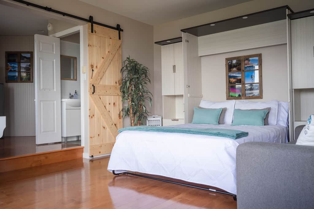Spacious Second Bedroom with Comfortable Seating and Privacy Doors